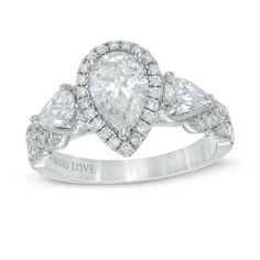 a pear shaped diamond engagement ring set in 18k white gold with diamonds surrounding the band