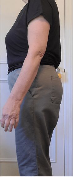 an older woman standing in front of a door with her hand on her hip and looking at the camera