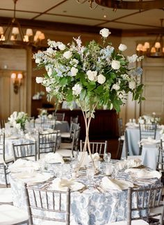 the centerpieces on this table are filled with white and blue flowers