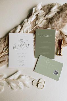 the wedding stationery is laid out on top of feathers and other items to be used for