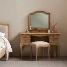 a bedroom scene with focus on the dressing table and stool, along with a bed