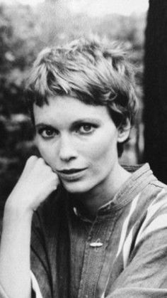 an old black and white photo of a woman with her hand on her chin looking at the camera