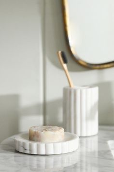 a bathroom counter with a soap dish and mirror in the backgroung area