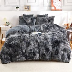 a bed covered in grey fur with pillows