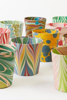 many different colored vases sitting next to each other on a white surface with one in the middle