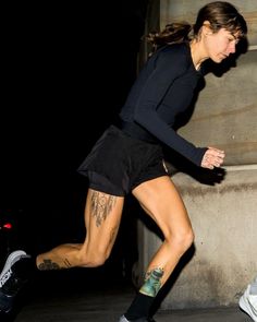 a woman in black shirt and shorts riding a skateboard