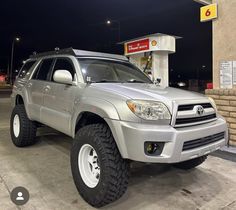 a silver toyota suv parked in front of a gas station