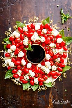 a wreath made out of tomatoes and mozzarella on top of a wooden table