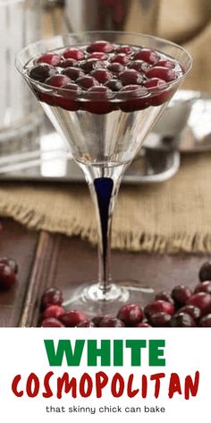 a martini glass filled with cherries on top of a table