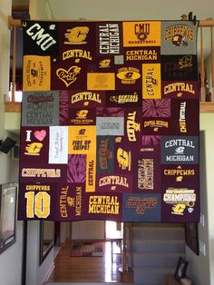 a college banner hanging from the ceiling in a room with stairs and pictures on it