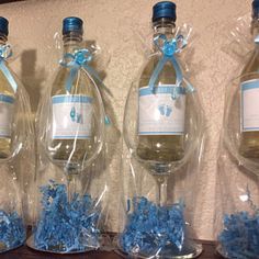 three wine bottles wrapped in plastic and tied with blue ribbon