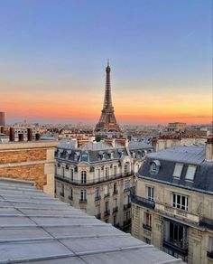 the eiffel tower towering over paris in the distance is seen from an apartment building