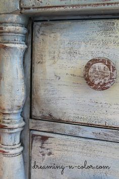 an old white painted dresser with some rusted knobs