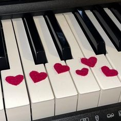 two hearts are placed on the keys of a piano