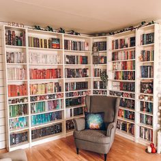 a chair in front of a bookshelf filled with lots of bookcases