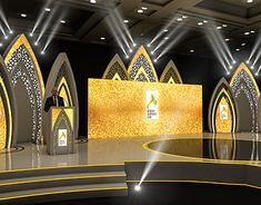 the stage is set up for an event with gold and silver decorations on it, while two men are standing at podiums