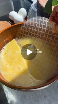 someone is mixing eggs in a bowl on the table with another person holding an object