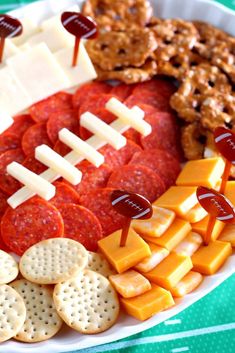 a football shaped cheese board with crackers, pretzels, and meats