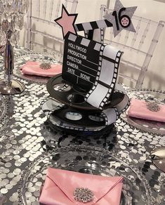 a table set up with pink napkins and place settings for a movie themed party