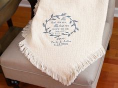 a white towel with blue lettering on it sitting on top of a chair