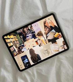 a cell phone laying on top of a bed covered in books and magazines next to a cup of coffee