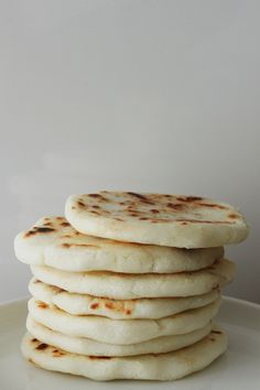 a stack of pita bread sitting on top of a white plate