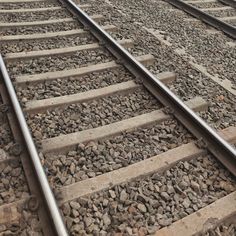 the train tracks are lined with rocks and gravel on one side, as if they were straight from the camera