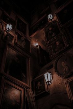 an old building with paintings on the wall and lights in the ceiling above it at night