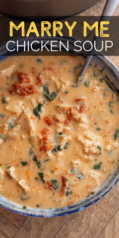 a bowl filled with chicken and spinach soup on top of a wooden table