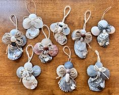 six seashell ornaments are hanging on a wooden table