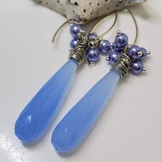 Elegantly Rich Periwinkle Chalcedony Long Dangle Tear Drop  Earrings, adorned with Lilac Pearls and Sterling Silver.  These earrings are perfect for an evening out, and transition easily from day to evening wear.   100% High Quality 100% Handmade You will receive the exact items shown Materials: Chalcedony Semi-Precious Gemstones 3mm Lilac Shell Pearls Silver Wire Wrapping .925 Sterling Silver Ear Wires Rubber Ear Backs All items purchased will be shipped within 1-3 Business Days, and are packag Tear Drop Earrings, Precious Gemstones, Silver Pearls, Tear Drop, Teardrop Earrings, Silver Wire, Semi Precious Gemstones, Sterling Silber, Ear Wires