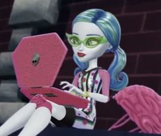 a cartoon girl with blue hair and green eyes using a pink laptop on her lap