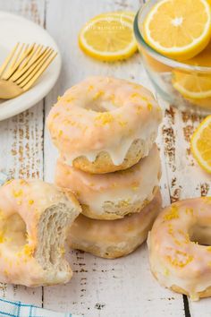 lemon donuts stacked on top of each other with slices of lemon in the background