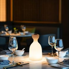 the table is set with wine glasses, plates and utensils