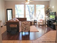 a living room filled with furniture and a flat screen tv on top of a hard wood floor