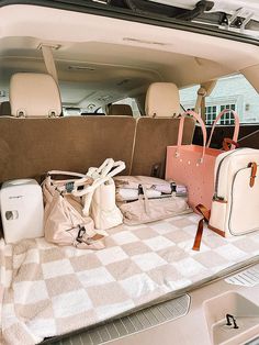 the back seat of a car filled with luggage and other personal items, including handbags