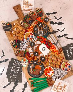 a table topped with lots of food and halloween decorations on top of a wooden board