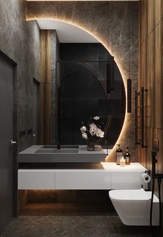 a modern bathroom with an oval mirror above the sink and toilet in front of it