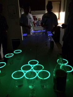 some people are standing around in the dark with glowing circles on the floor, and one person is looking at them