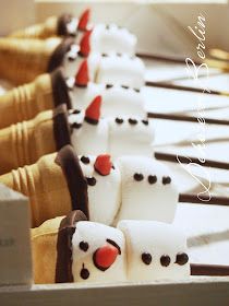 there are many marshmallows in the shape of snowmen lined up on a table