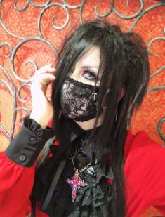 a woman with long black hair wearing a mask