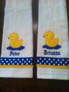 two white towels with yellow rubber ducks and blue polka dot trimmings on them