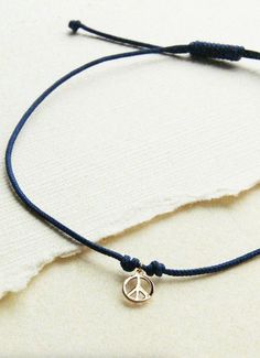 A peace sign symbolizes the free spirit, who trusts their inner guidance and has unwavering values. Featuring a mini version of our top-selling peace sign design, cast in 10k recycled yellow gold, the moonchild contemplation cord bracelet encircles your wrist as a reminder to contemplate the love and peace within you. Material 10k recycled yellow gold navy blue nylon cord Details Bluboho is a fine jewelry company that carries ethically sourced, raw and refined jewelry pieces. Bluboho creates jew Minimalist Blue Jewelry With Adjustable Cord, Adjustable Spiritual Jewelry With Peace Sign, Symbolic Peace Sign Jewelry For Gift, Peace Sign Design, Blue Multi-strand Spiritual Jewelry, Vintage Peace Sign Jewelry Gift, Adjustable Peace Sign Necklace, Love And Peace, Inner Guidance