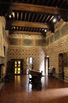 an old room with a fireplace and ornate wallpaper