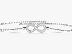 a silver bracelet with an infinite sign on the clasp and diamonds in the middle,