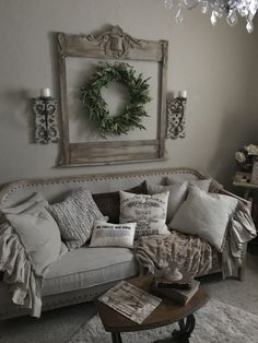 a living room with a couch, coffee table and wreath on the wall above it