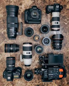 many different types of cameras sitting on top of a table next to eachother