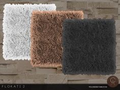 three different colors of shaggy rugs against a brick wall