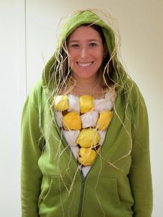 a woman wearing a green hoodie with yellow and white food on it's chest