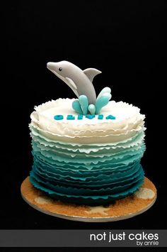 a blue and white cake with a dolphin on top